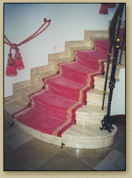 Treppenhaus mit rotem Teppich und Naturstein